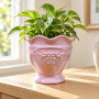 Rosa kruka Rosalie på fot från CaesarCollection med en liten grön växt på en träbyrå