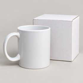 Vit kaffe- och temugg utan motiv bredvid medföljande vit ask